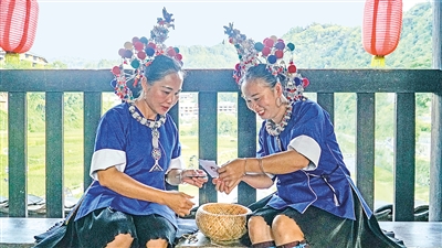     程陽橋上，侗族婦女在展示制作侗族刺繡產(chǎn)品。繡品圖案精美、色彩艷麗，成為當?shù)靥厣a(chǎn)業(yè)。